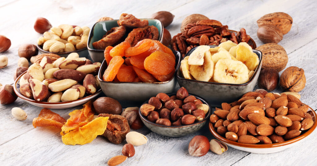 dried fruits and assorted nuts composition on rustic table.